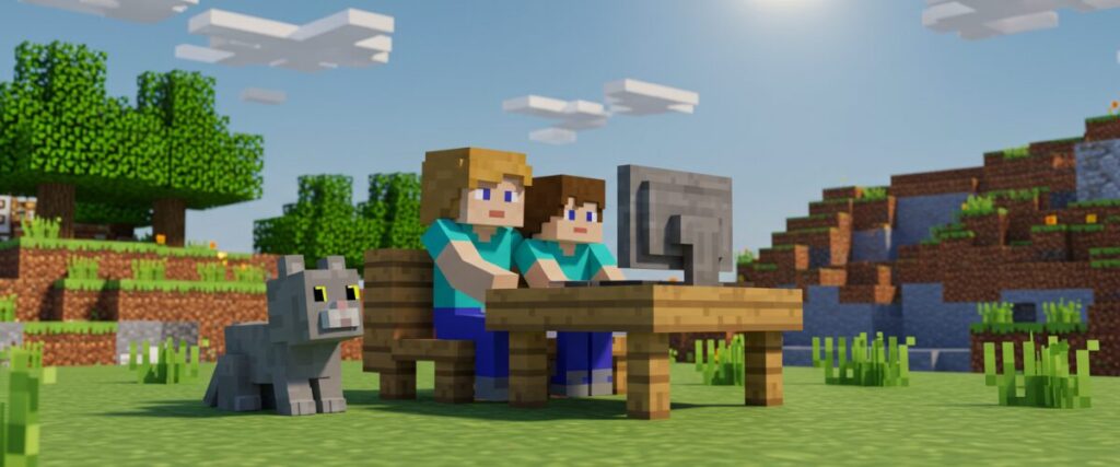 マイクラ風の草原で、親子キャラクターが木製テーブルのパソコンを一緒に操作し、横にブロック調の猫が座っているイラスト。